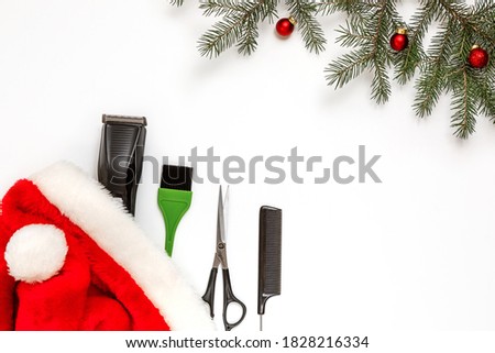 Christmas composition. Hairdressing tools in a Santa Claus hat on a white background. Template for a postcard or information about a hair salon. Flat lay, copy space.