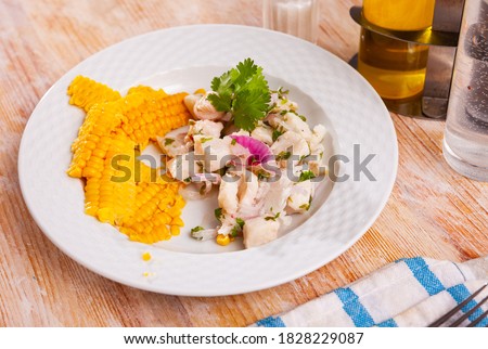 Healthy ceviche of marinated cod fillet served with side dish of boiled corn seeds