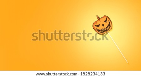 Paper pumpkin on stick. Prop for photo and party on bright yellow-orange background. Minimal Halloween concept. Banner, top view, flat lay, space for text