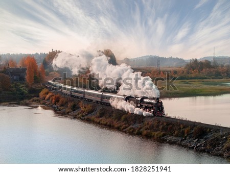 Vintage steam locomotive train in the autumn landscape. Royalty-Free Stock Photo #1828251941