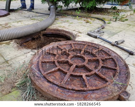 The open hatch of the septic tank. The cast-iron lid is next to it. Sewage treatment