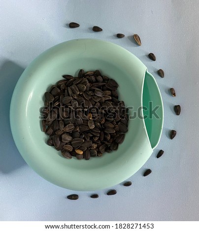 Black sunflower seeds in blue bowl