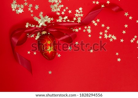 Christmas tree vintage decoration with ribbon and golden details on red stars confetti background top view  New Year greeting card 