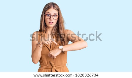 Young beautiful blonde woman wearing casual clothes and glasses in hurry pointing to watch time, impatience, upset and angry for deadline delay  Royalty-Free Stock Photo #1828326734