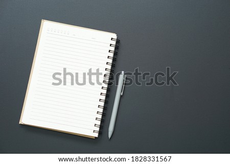 top view of open blank notebook with grey pen on black background and blank space in the right side for edit your text, copy space concept.