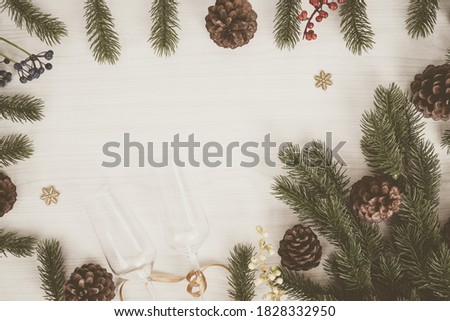 Christmas Holidays background. Christmas Season Wishes and Border of Realistic Looking Christmas Tree Branches Decorated with Berries, pine cones, for branches on wooden , top view, copy space