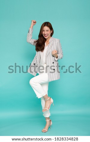 Attractive beautiful Asian woman standing and hands up raised arms from happiness, Excited businesswoman winner success concept