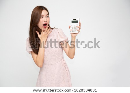 Portrait of excited Asian woman holding calculator isolated on white background, Wow and surprised concept