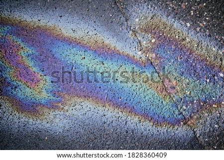 Gas stain on wet asphalt caused by a leak under a car or truck, abstract background Royalty-Free Stock Photo #1828360409
