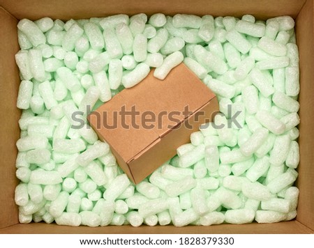 Cardboard Box with Packing Peanuts or Pellets From Top View. Isolated on White Background. 
