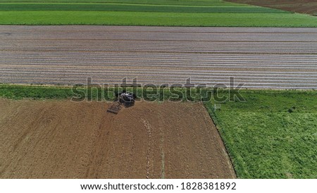 An Aerial shot of donkeys pulling farming equipment