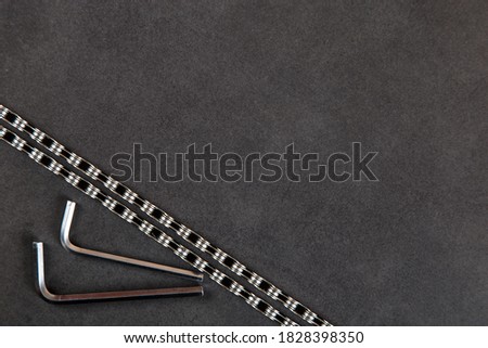 Bicycle chain and hexagonal keys on stone table, background for bicycle workshop, copy space.