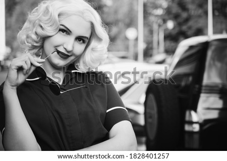 smiling young blond woman retro style portrait at parking, monochrome