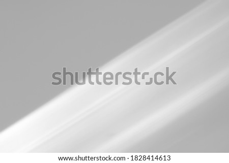 Blurred diagonal shadows from a window on a white wall. Monochrome overlay for mockups. Royalty-Free Stock Photo #1828414613