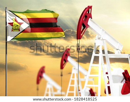Oil rigs against the backdrop of the colorful sky and a flagpole with the flag of Zimbabwe. The concept of oil production, minerals, development of new deposits.