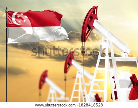 Oil rigs against the backdrop of the colorful sky and a flagpole with the flag of Singapore. The concept of oil production, minerals, development of new deposits.