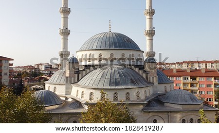 white & grey mosque with two beautiful minarets and dome at sunset drone shot