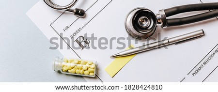 Medical concept. Yellow pills with stethoscope, pills, notepad, medical prescription, pen on the doctor's desktop. Treating a patient in a hospital with medication.