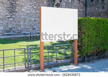 white information banner with empty place for mockup on wooden poles at city street outside