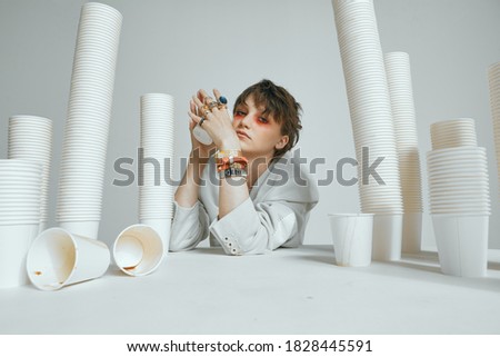 Tired sleepy girl with lots of paper cups. Chronic lack of sleep and caffeine dependence