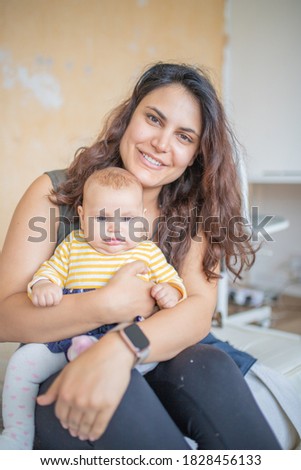Mother Holding Her Baby Girl on Her Arms