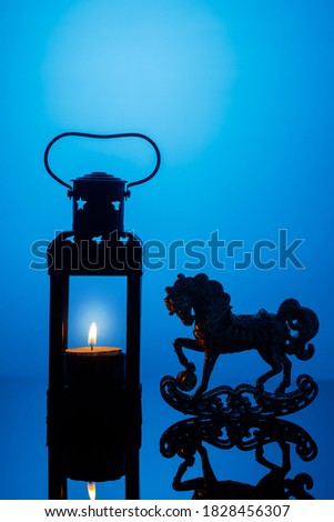 christmas postcard with lantern with burning candle and horse silhouette