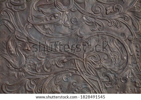 Background image - a floral pattern in the form of embossing on metal