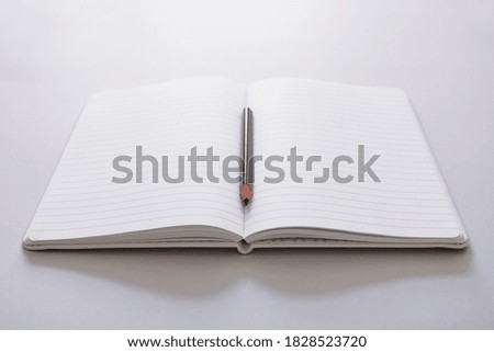 A studio photo of a White note book
