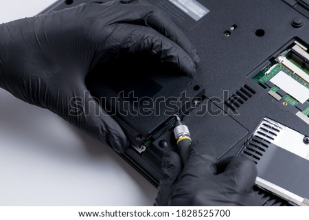 technician worker repairing laptop pc. restore hard disk data store concept. computer hardware repair service conceptual. person checking hdd disk. Royalty-Free Stock Photo #1828525700