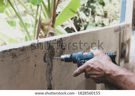 Drill screwdriver, rotary hammer drills holes in concrete for construction