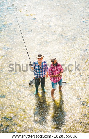 Father and adult son fishing lakeside. Man bearded fisher. Mature man fly fishing. Keep calm and fish on. Luxury life concept. Senior man gone fishing