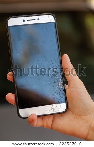 Broken glass of smart phone. Selective focus. the girl holds in her hand an accidentally broken phone. cracks on the smartphone screen.