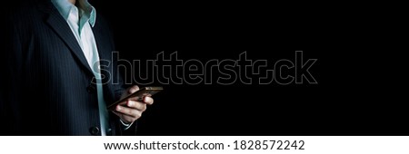 Banner businessman using smartphone on isolated black background