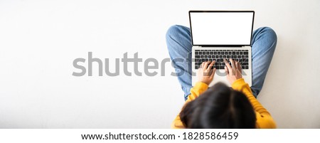 Top view of woman sitting on floor and using laptop blank screen white background. Mockup, template for your text, Clipping paths included for device screen. Panoramic image with empty copy space Royalty-Free Stock Photo #1828586459
