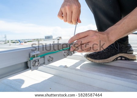 installing grounding in steel bar of solar rooftop power system by barehanded stock photo