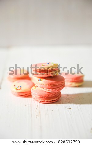 Lots of macarons placed on a plain background.