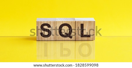 sql word written on wood block. office word is made of wooden building blocks lying on the yellow table