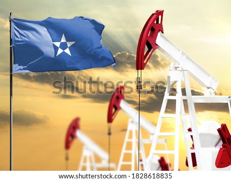 Oil rigs against the backdrop of the colorful sky and a flagpole with the flag of Somalia. The concept of oil production, minerals, development of new deposits.