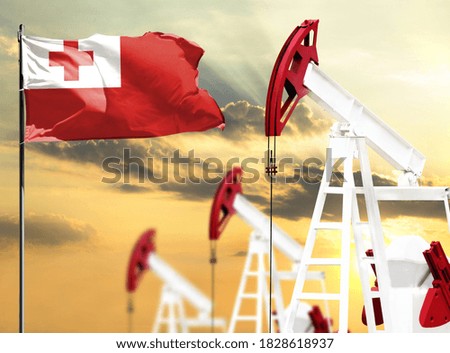 Oil rigs against the backdrop of the colorful sky and a flagpole with the flag of Tonga. The concept of oil production, minerals, development of new deposits.