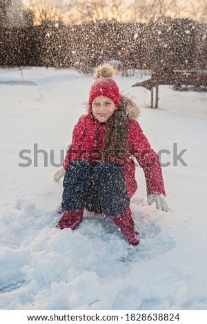 portrait of a girl walking in the winter outdoors. playing with snow.