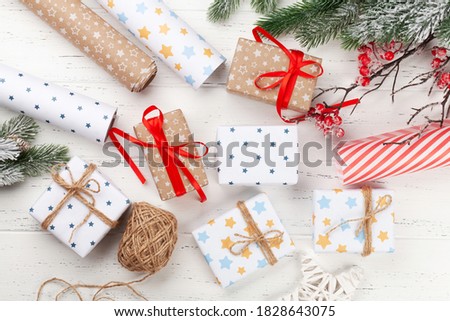 Christmas gift boxes packaging, paper rools, decor and fir tree. Top view flat lay