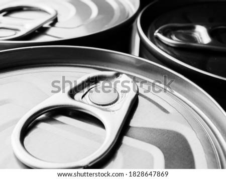 A close-up picture of the side on the can lid of the canned food is black and white as the background