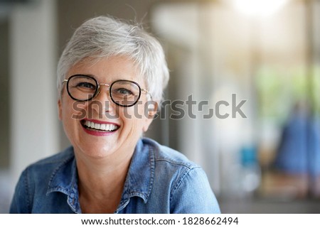 portrait of a beautiful smiling 55 year old woman with white hair Royalty-Free Stock Photo #1828662494