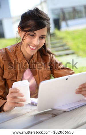 Portrait of student girl using tablet in park