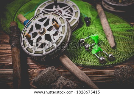 Old rarity bottom fishing reels on a wooden background. Bell, fish tank and makuha cubes. Studio photo.