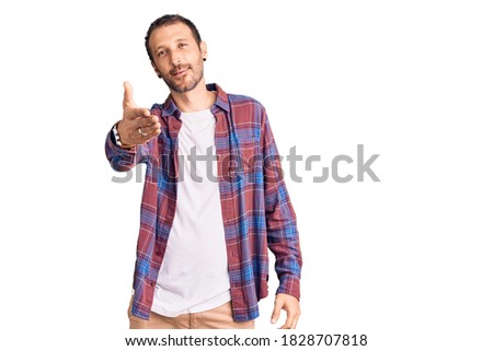 Young handsome man wearing casual clothes smiling cheerful offering palm hand giving assistance and acceptance. 