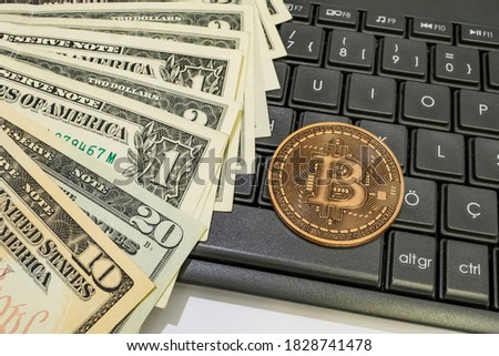 close up bitcoin coin with US dollars and computer keyboard
