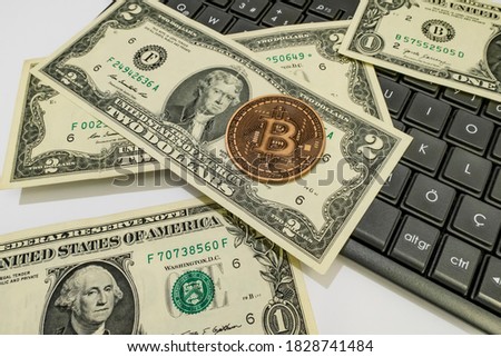 close up bitcoin coin with US dollars and computer keyboard