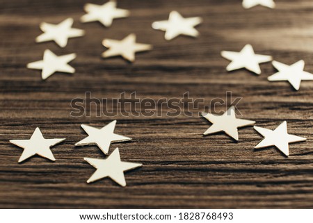 Festive creative background with sparkling confetti in the shape of stars. Selective focus. Close up. Space for text.