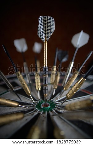 Lots of darts stuck randomly into the dartboard. One dart hit the center in the bull's eye Royalty-Free Stock Photo #1828775039
